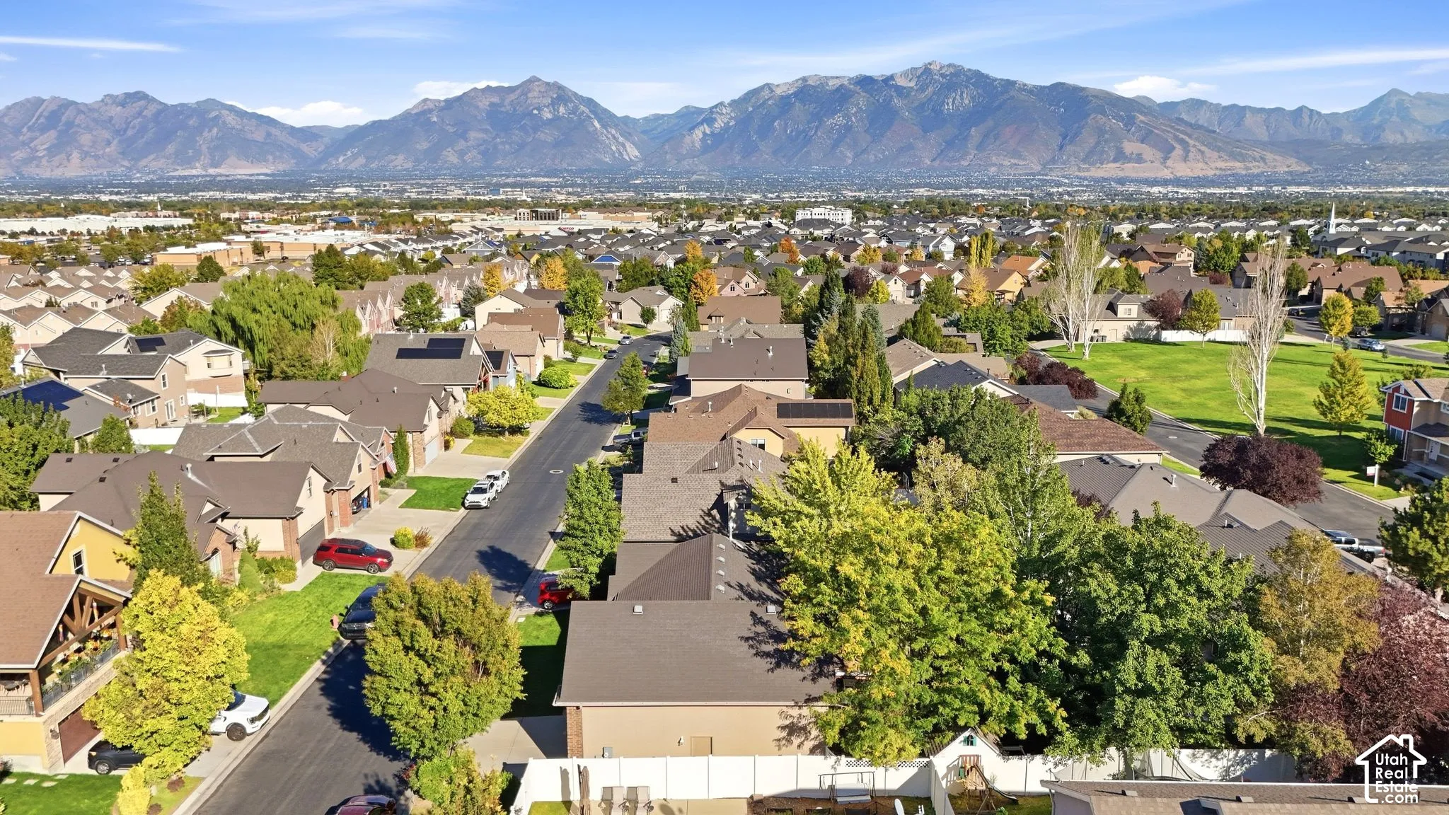 Expansive neighborhood setting with mature trees and mountain scenery
