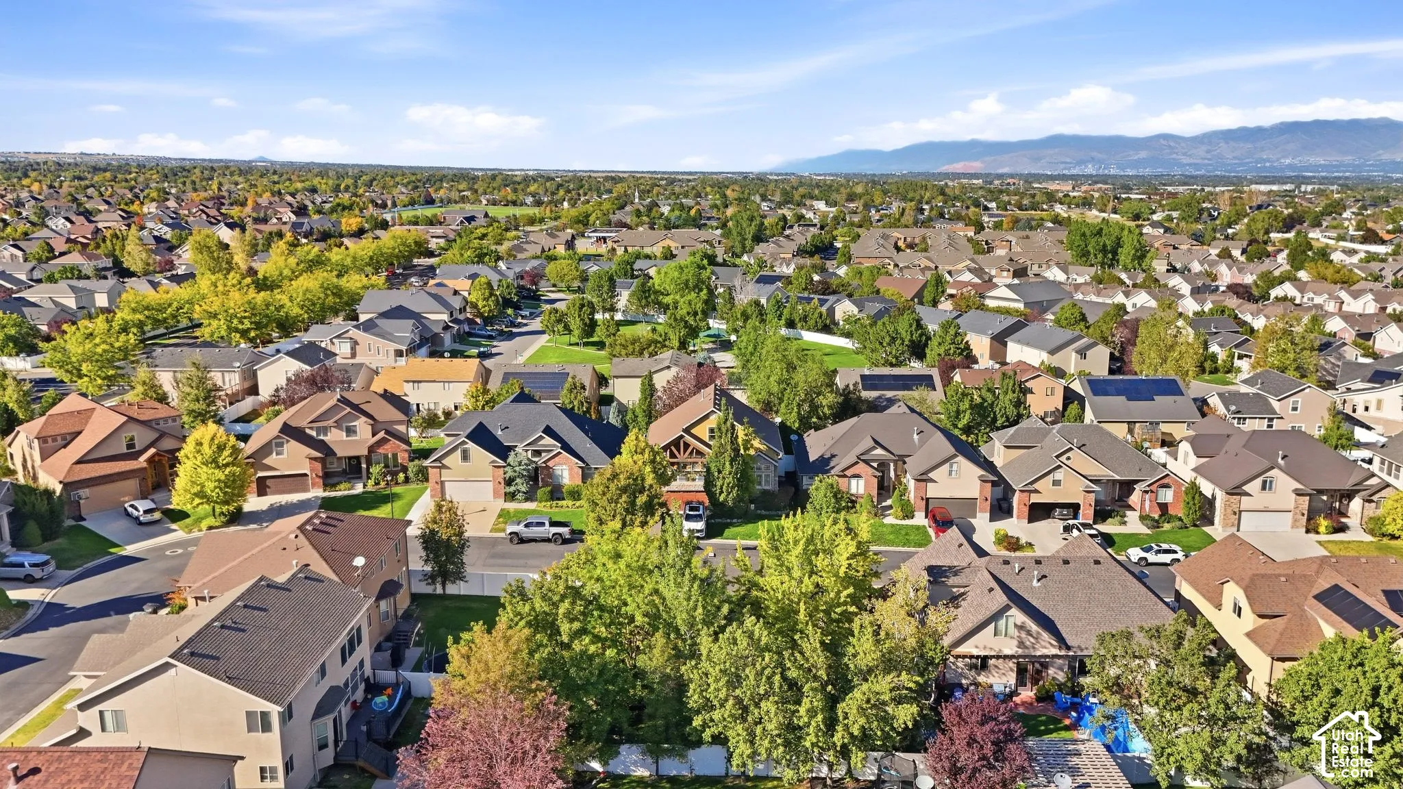 Expansive residential neighborhood featuring diverse architectural styles, mature trees, and mountainous terrain in the distance