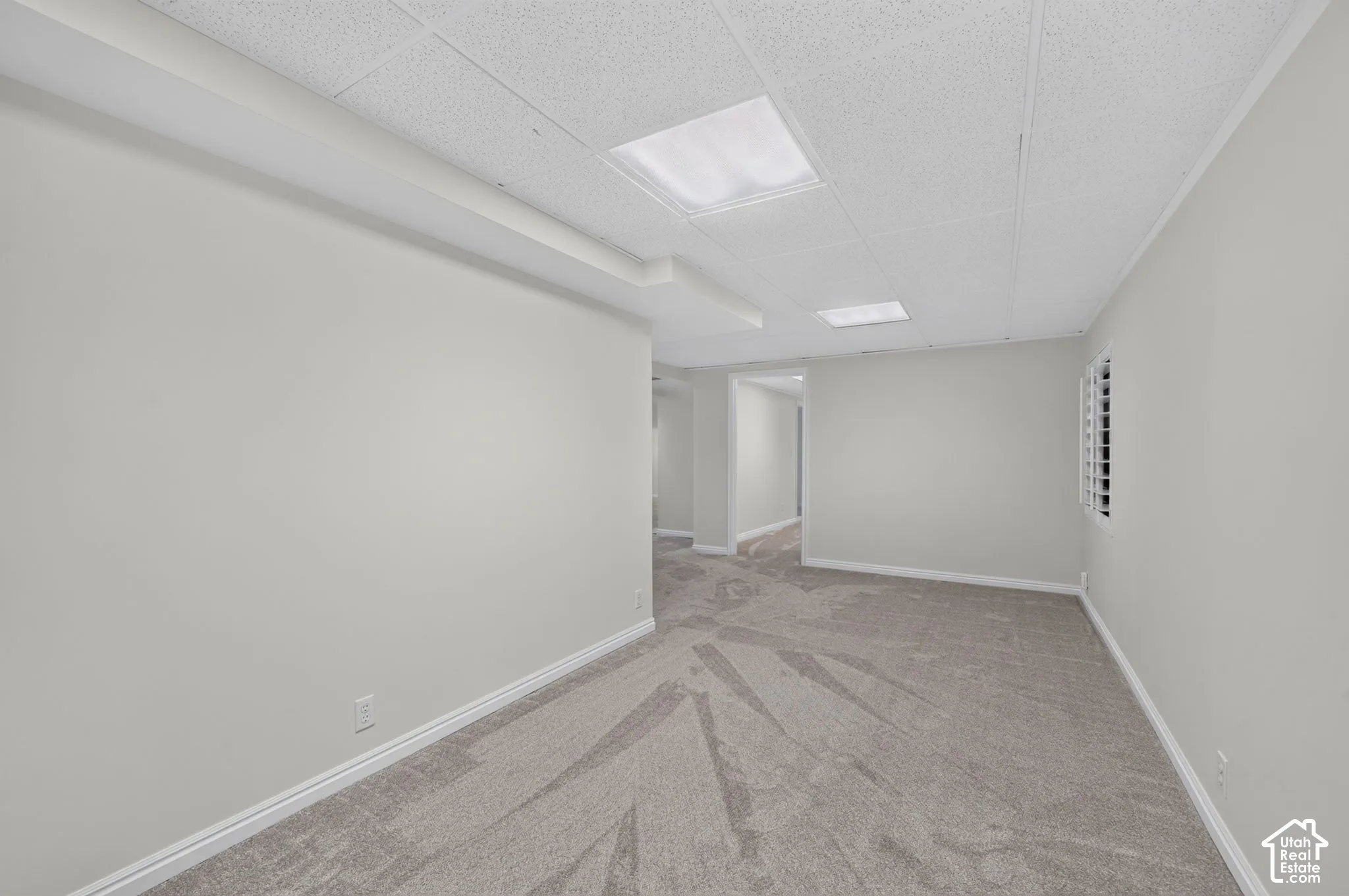 Recessed lighting, textured ceiling, light gray carpeting, white walls, and white plantation shutters