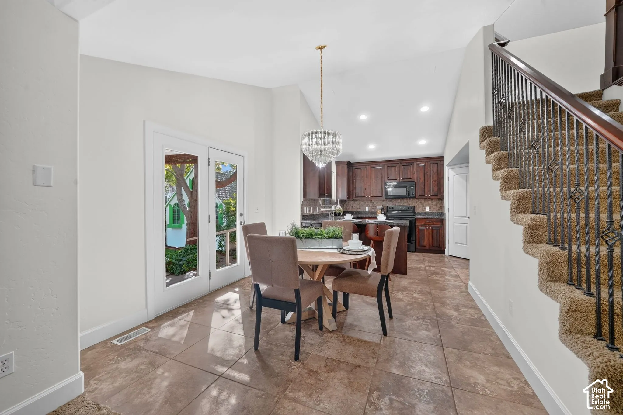 White French doors, vaulted ceilings, and a crystal chandelier