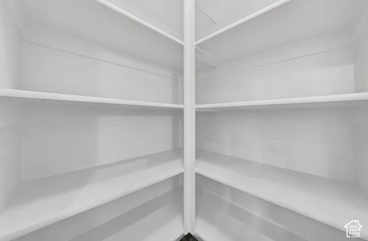 Built-in white shelving system with a central vertical support and multiple horizontal shelves
