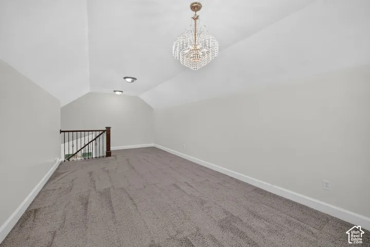 Spacious bonus room featuring vaulted ceilings, recessed lighting, a chandelier, and carpet flooring