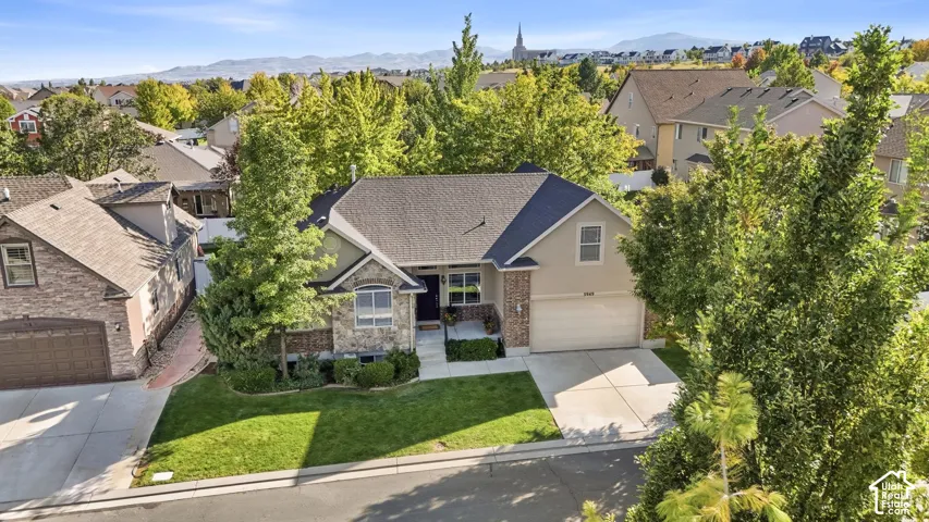 Traditional-style residence featuring a combination of stone and siding exterior, an attached garage, and a concrete driveway