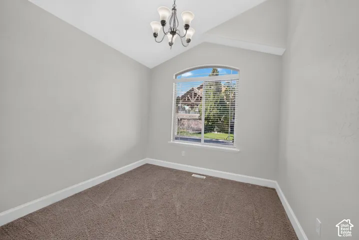 Arched window with blinds, vaulted ceiling, recessed lighting, and neutral-toned carpeting