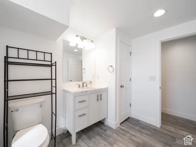 White vanity with a stone-finish countertop, under-mount sink, and brushed nickel hardware
