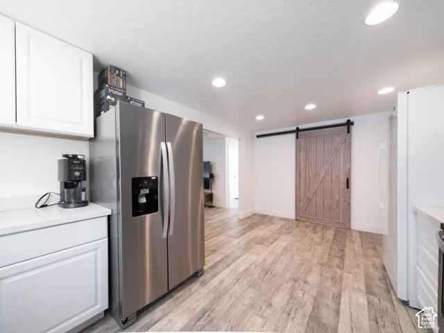 Kitchen featuring recessed lighting, wood-finish flooring, white cabinetry, and light-toned countertops