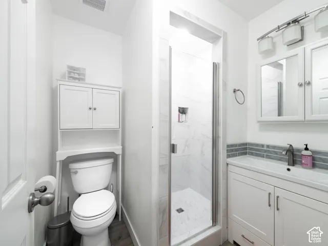 White vanity with an integrated sink, polished chrome faucet, and gray subway tile backsplash