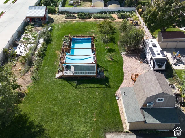 Expansive lot featuring a large lawn, an above-ground pool with a surrounding deck, and a detached structure with a gambrel roof