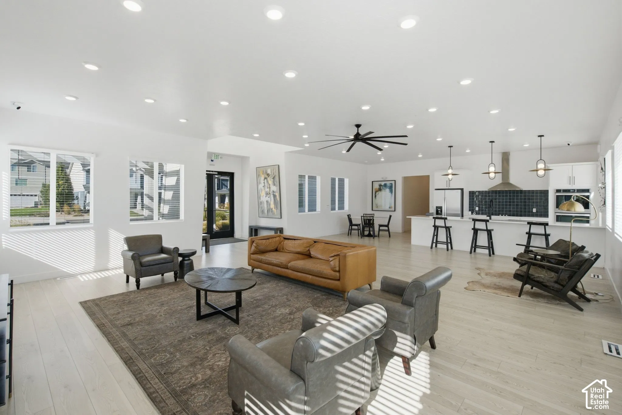 Expansive open-concept living area featuring light wood-finish flooring and recessed lighting
