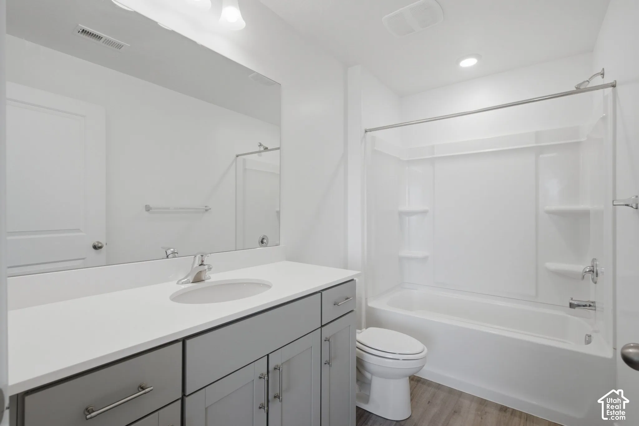 White vanity with gray cabinetry and brushed nickel hardware