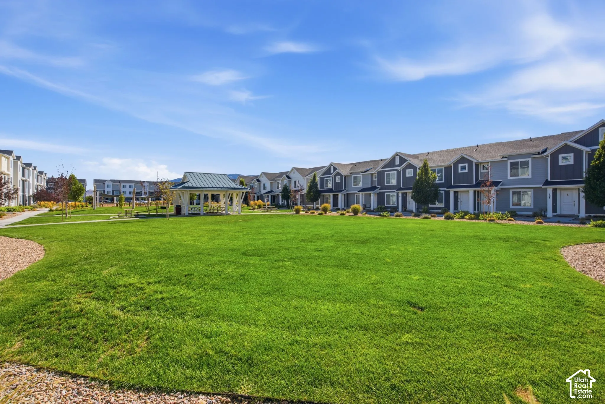Expansive green space featuring a white gazebo with a metal roof