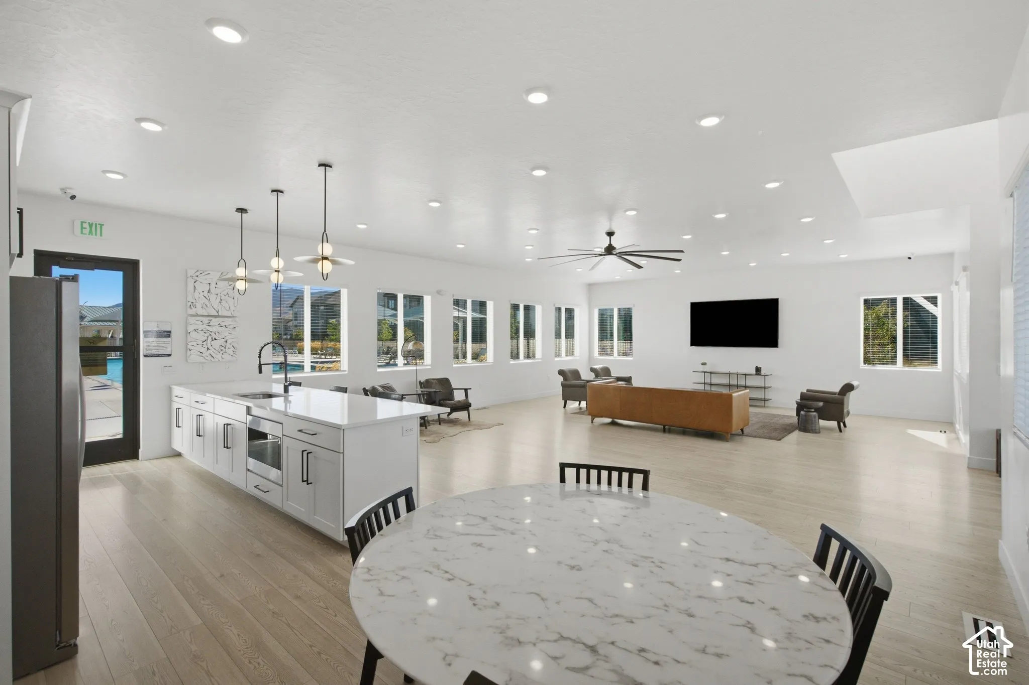 Spacious open-concept room featuring wood-finish flooring, recessed lighting, and multiple windows