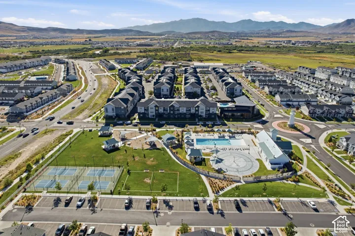 Aerial perspective featuring residential buildings, a community swimming pool, and tennis courts