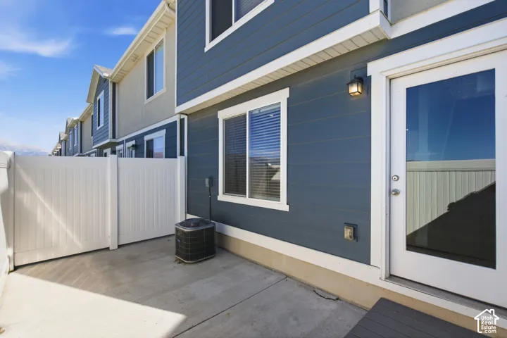 Private concrete patio with a white vinyl fence