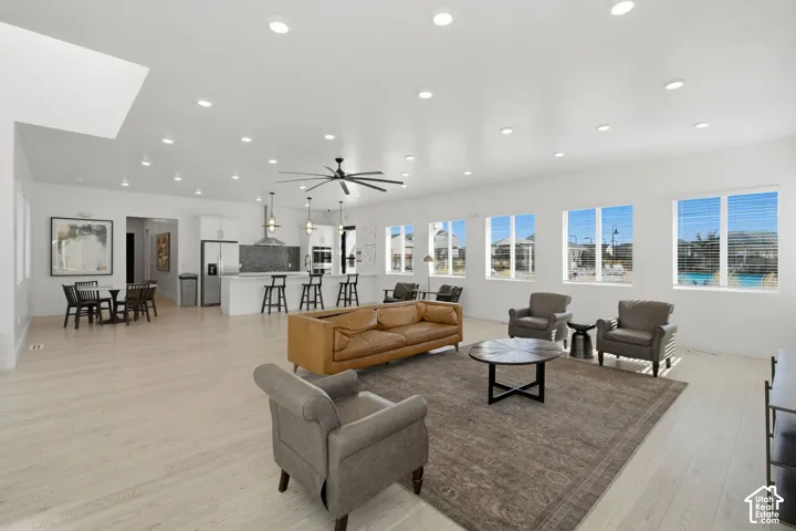 Open-concept living space featuring wood-finish flooring, recessed lighting, and multiple windows
