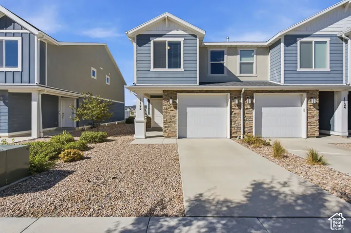 Two-story residence featuring light blue horizontal siding and stone veneer accents