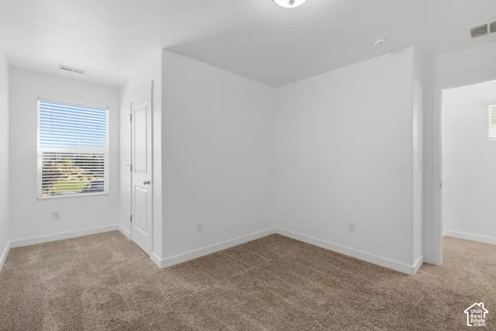 Carpeted flooring, white walls, window with blinds, and white trim