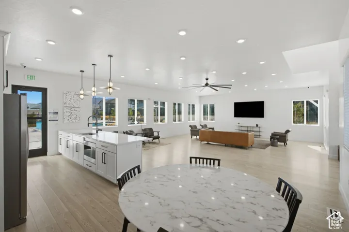 Spacious open-concept room featuring wood-finish flooring, recessed lighting, and multiple windows