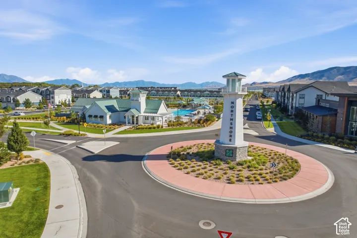 Community entry with a lighthouse monument, surrounding residential structures, and a clubhouse with an outdoor swimming pool