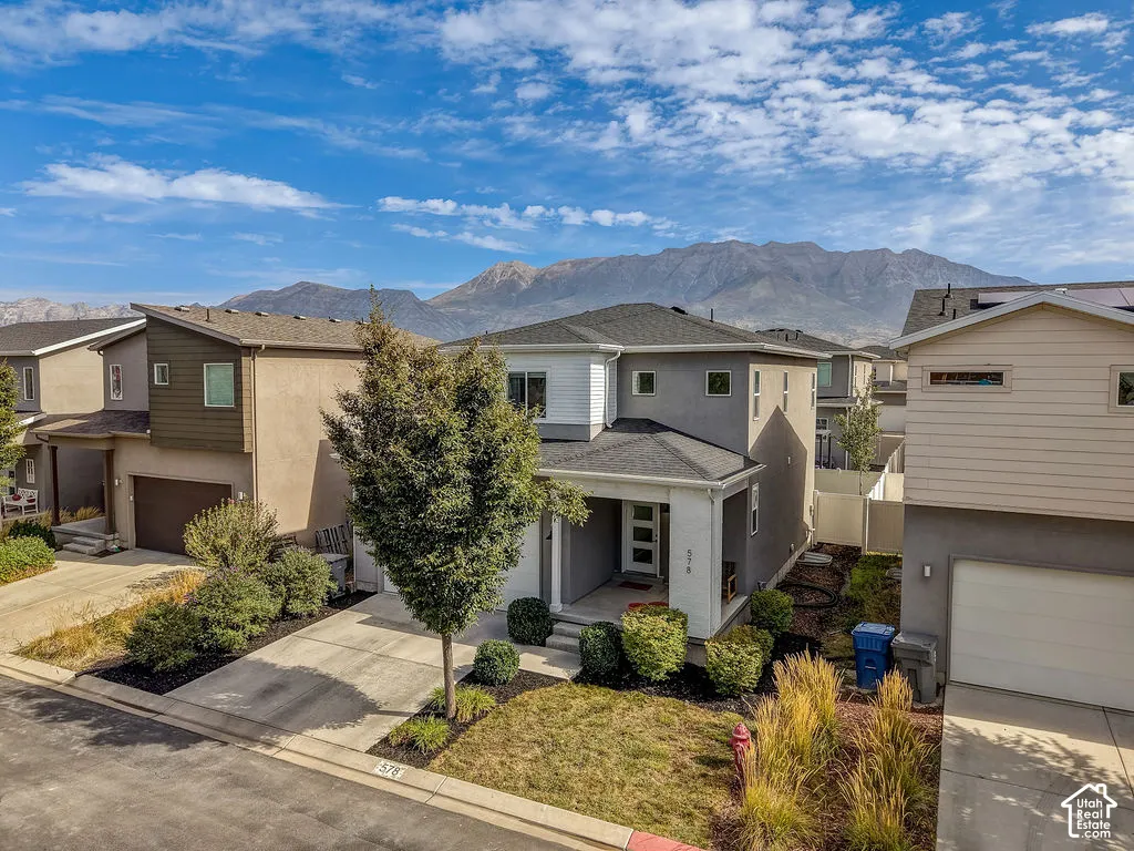 Contemporary exterior with a covered entry, stucco and siding finishes, a well-maintained front yard, and a concrete driveway