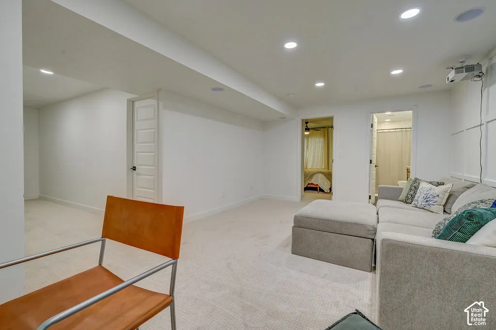 Recessed lighting, light-toned carpeting, white interior walls, and ceiling-mounted projector