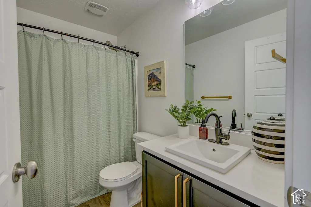 Bathroom featuring a vanity with dark cabinetry, white countertop, and integrated sink
