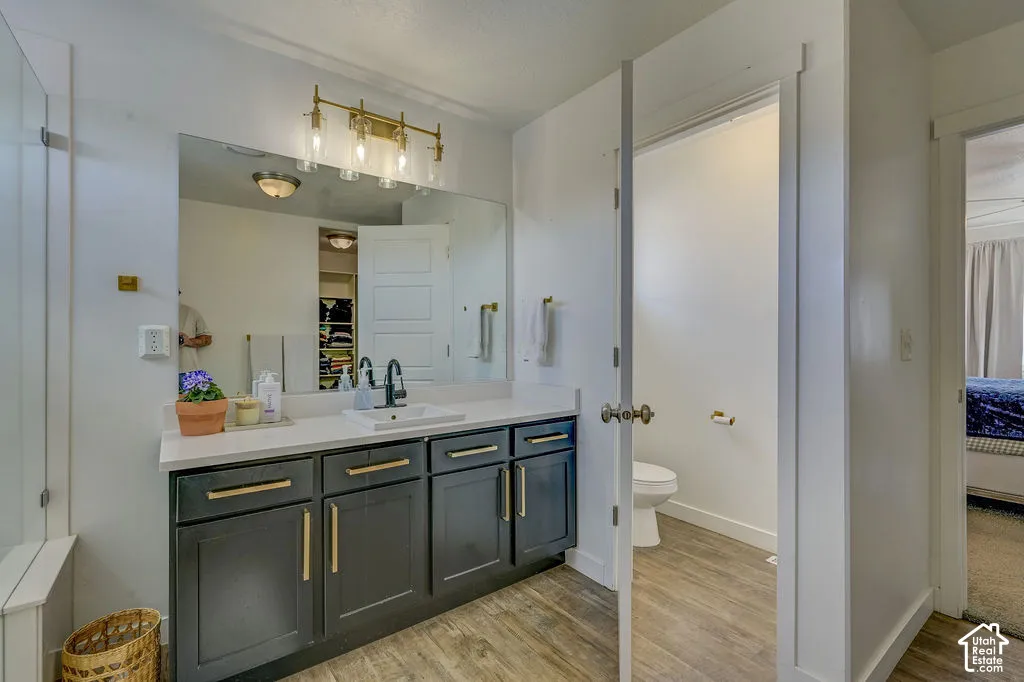 Dual vanity with a white countertop and dark cabinetry, illuminated by a four-light fixture