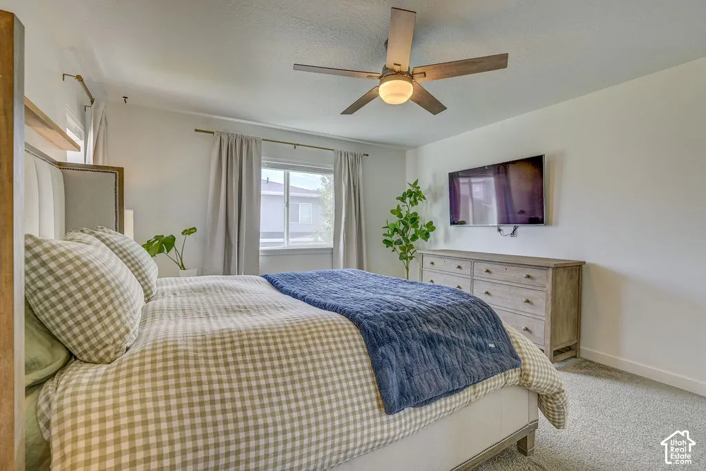 Recessed lighting, ceiling fan with integrated lighting, window with light-filtering drapes, wall-mounted television, and wood-finish dresser