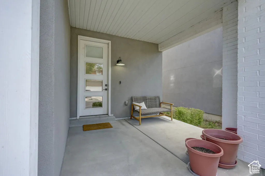 Covered concrete porch with white brick column