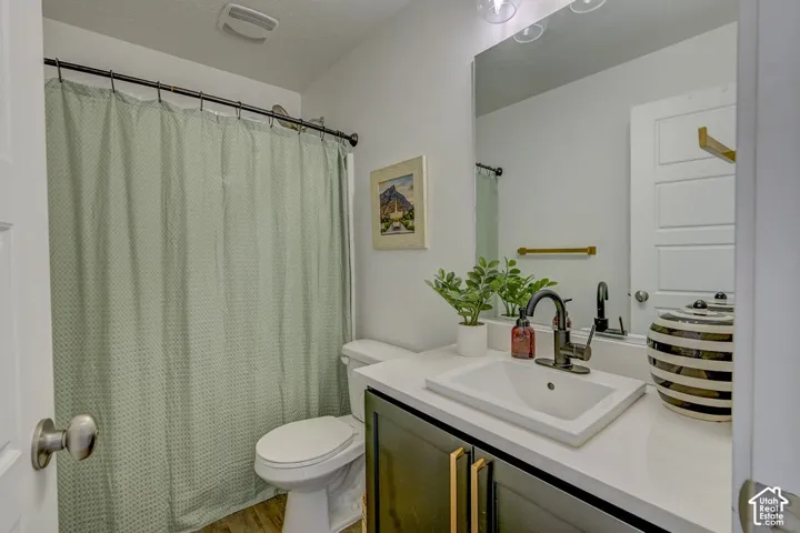 Bathroom featuring a vanity with dark cabinetry, white countertop, and integrated sink