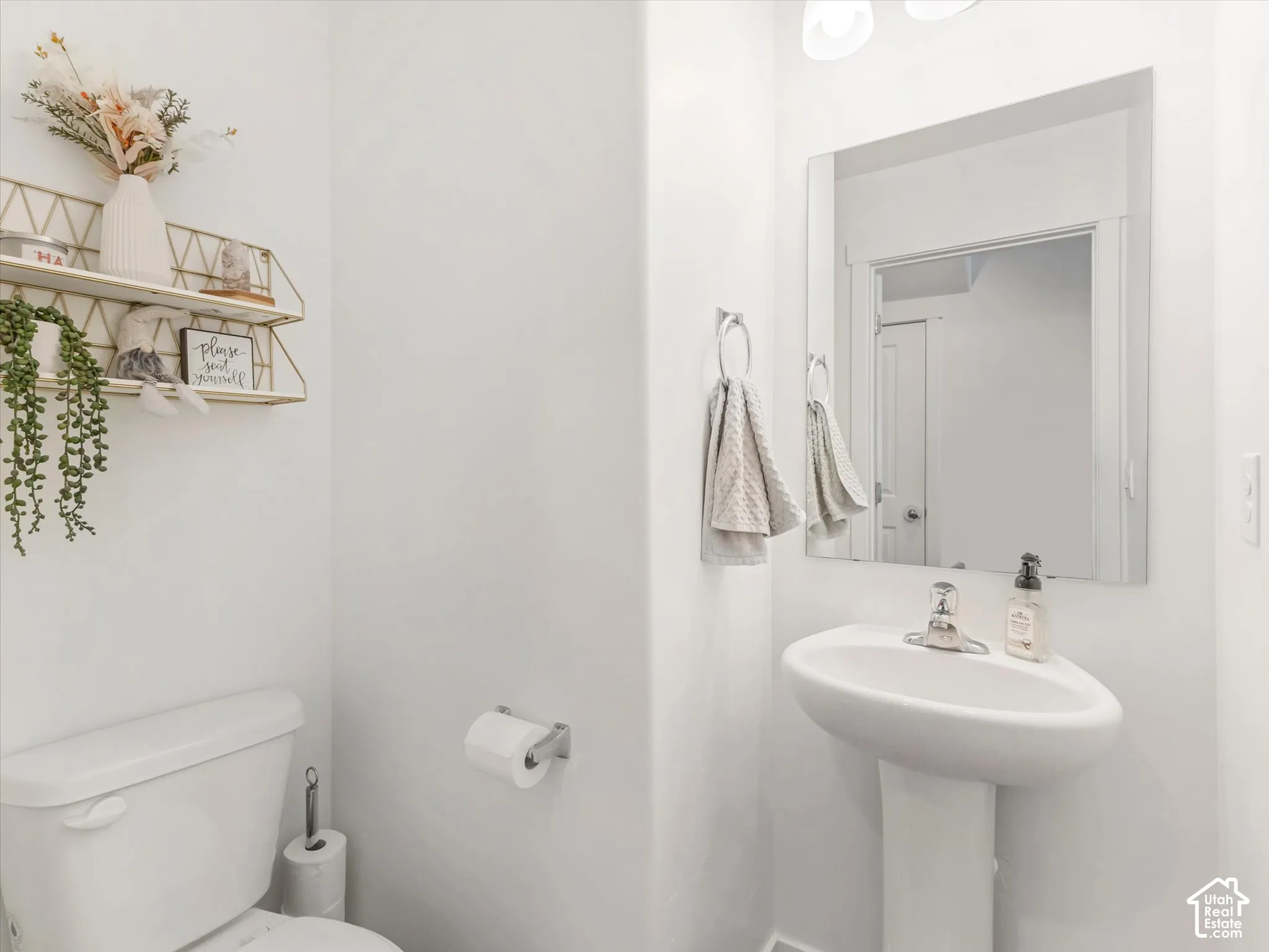 Pedestal sink with chrome faucet, square vanity mirror, and recessed lighting