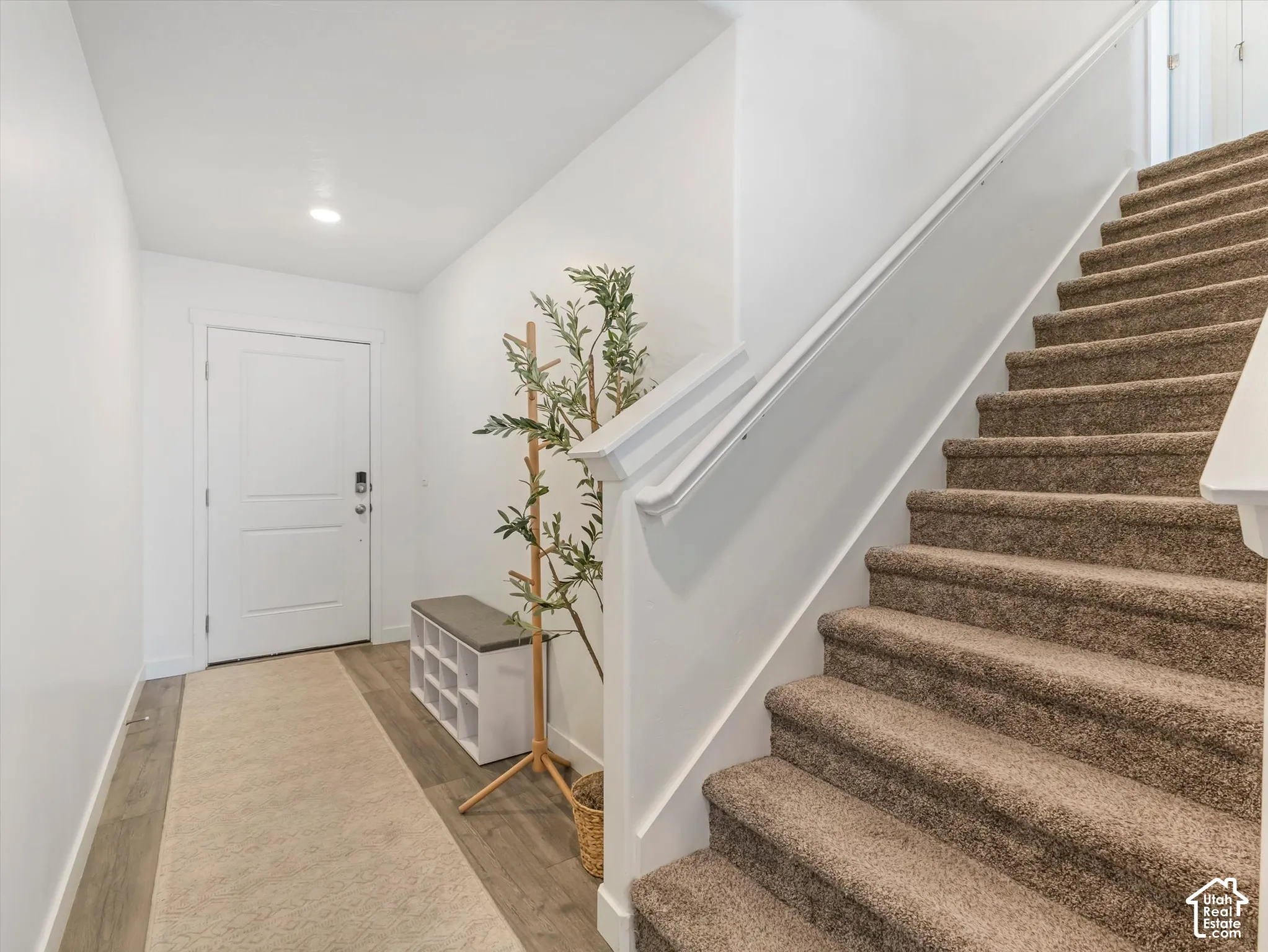 Entryway featuring wood-finish flooring, a white paneled door, and recessed lighting
