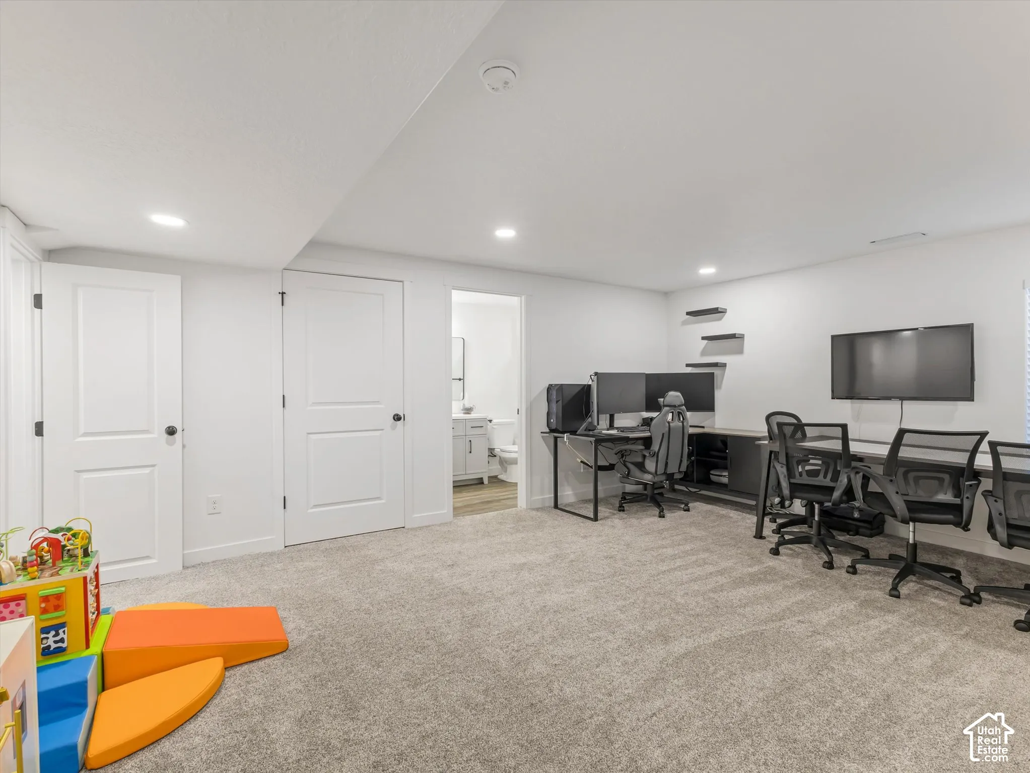 Recessed lighting illuminates the carpeted floor