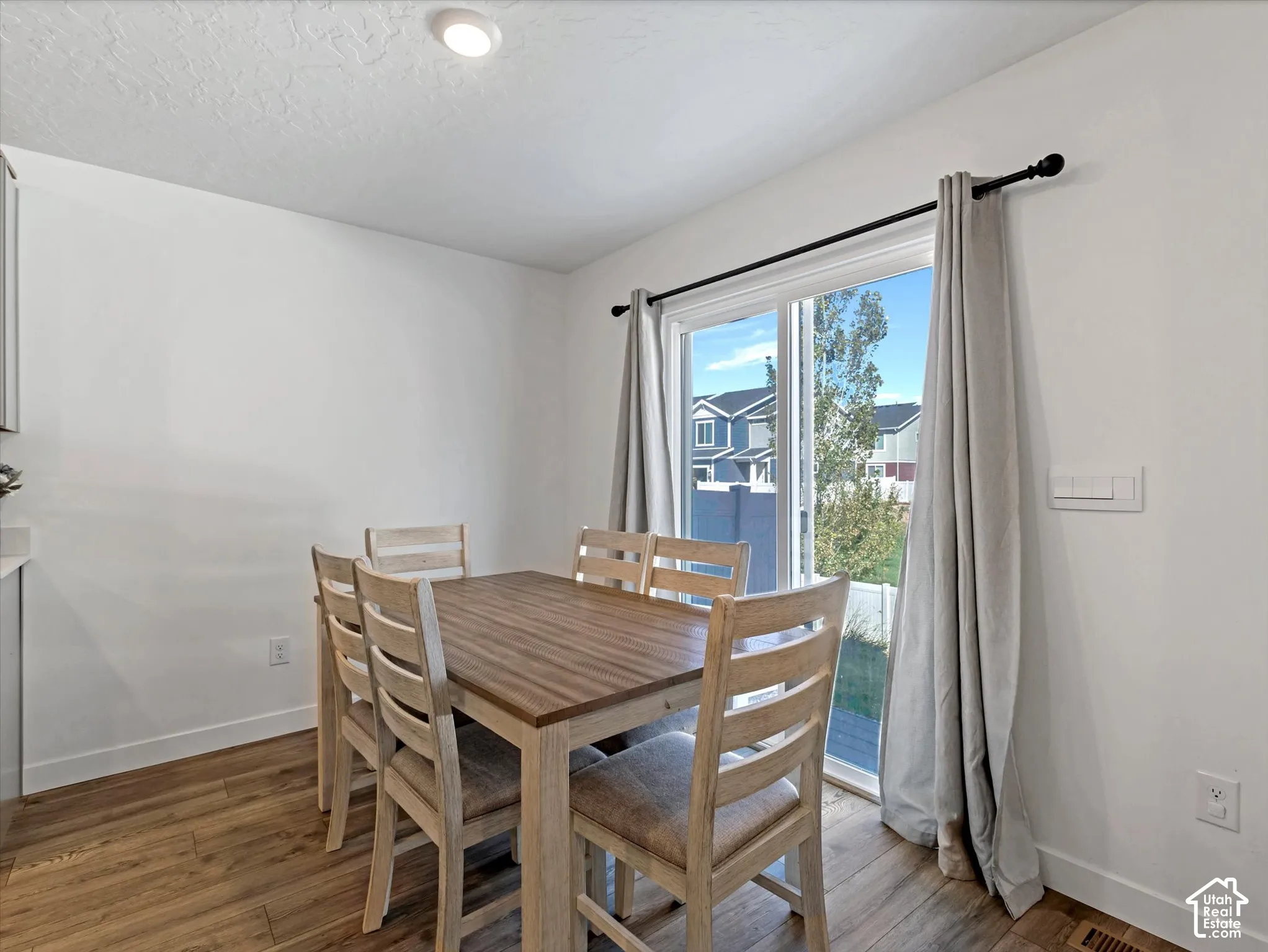 Recessed ceiling lighting, wood-finish flooring, sliding glass door, white walls, and built-in cabinetry