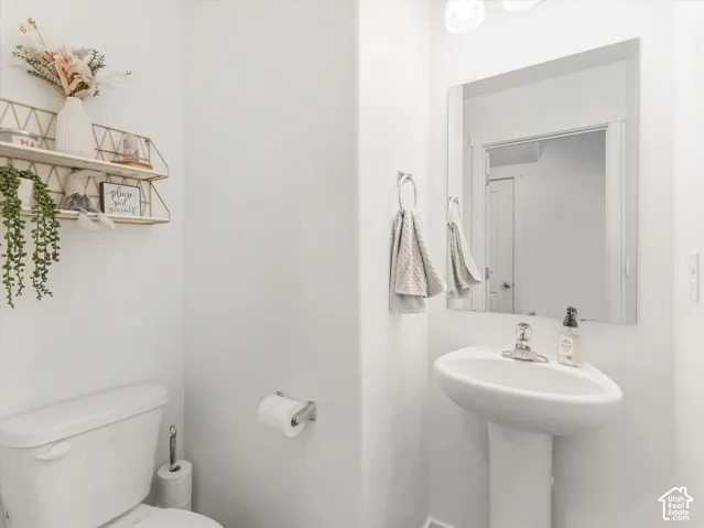 Pedestal sink with chrome faucet, square vanity mirror, and recessed lighting