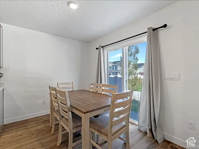 Recessed ceiling lighting, wood-finish flooring, sliding glass door, white walls, and built-in cabinetry