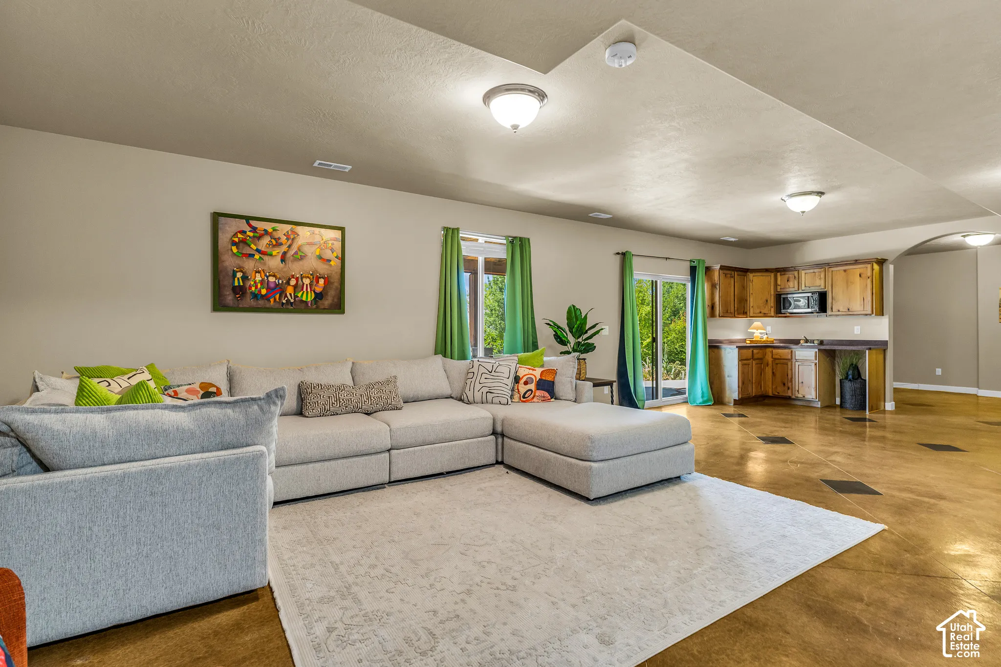 Expansive living area with large sliding glass doors, built-in cabinetry, recessed lighting, and a compact kitchen area
