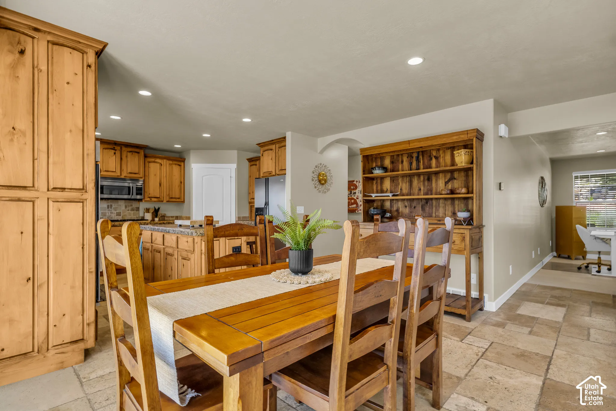 Kitchen with wood cabinetry, stainless steel appliances, and a tiled backsplash