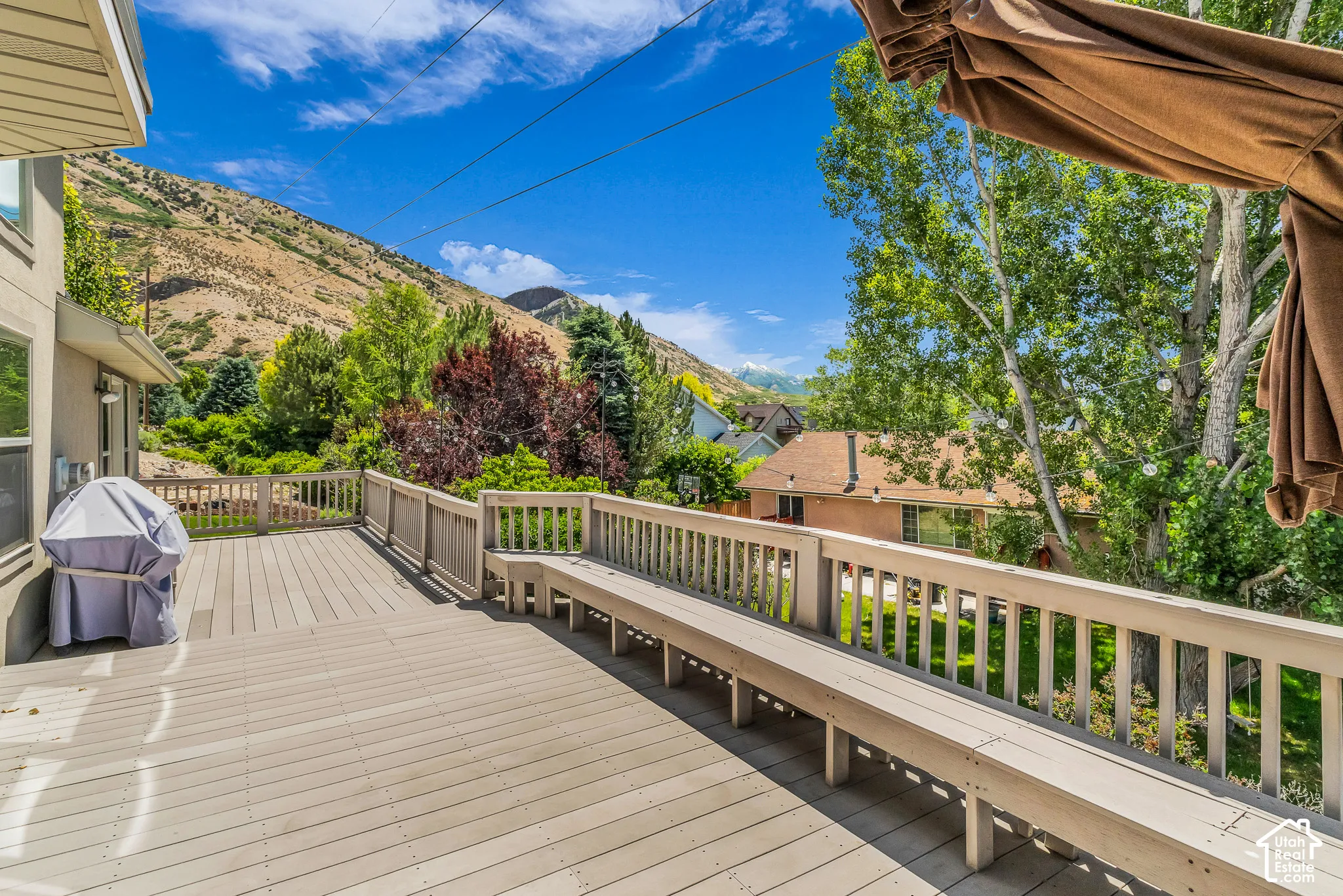 Expansive outdoor deck with built-in bench seating and wood railing