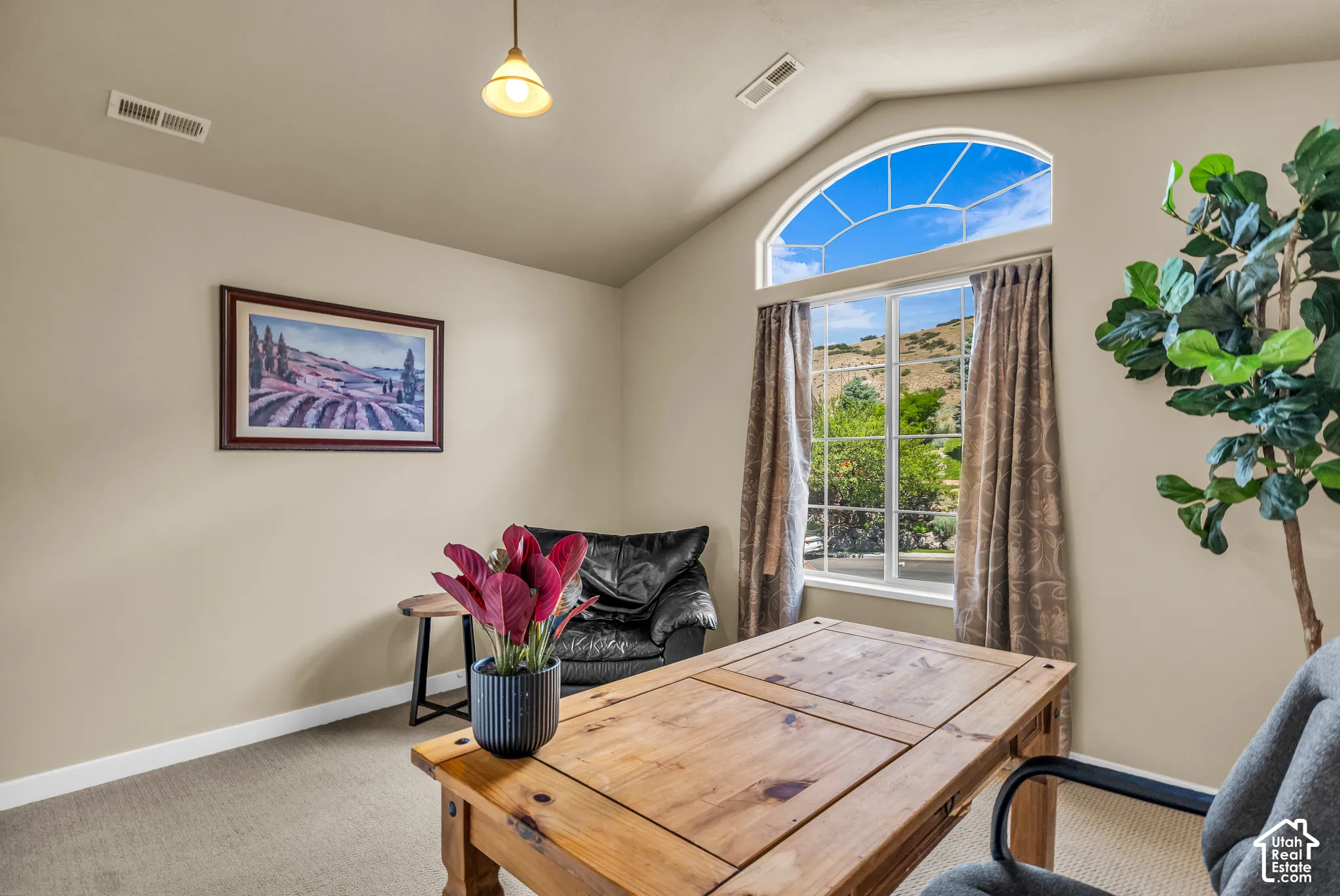 Vaulted ceiling with an arched transom window, beige carpeting, and neutral wall tones