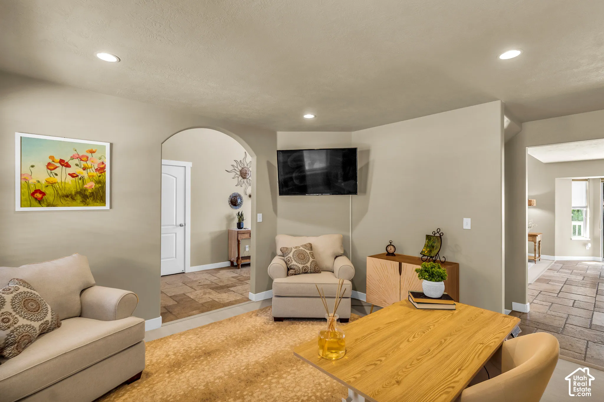 Recessed ceiling lighting, arched doorway, and light-toned wall finishes