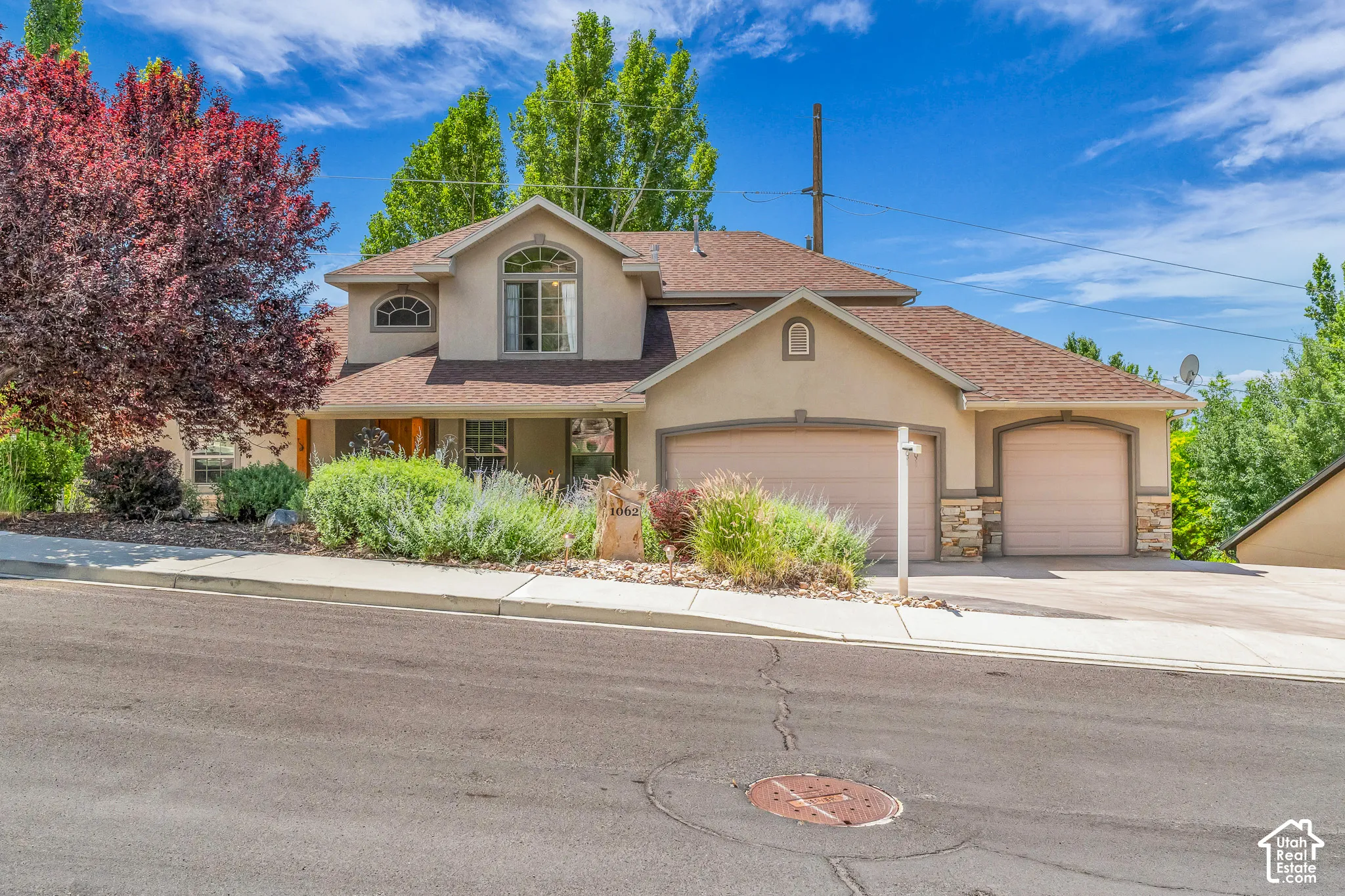 Stucco exterior with stone accents, arched windows, and a two-car garage