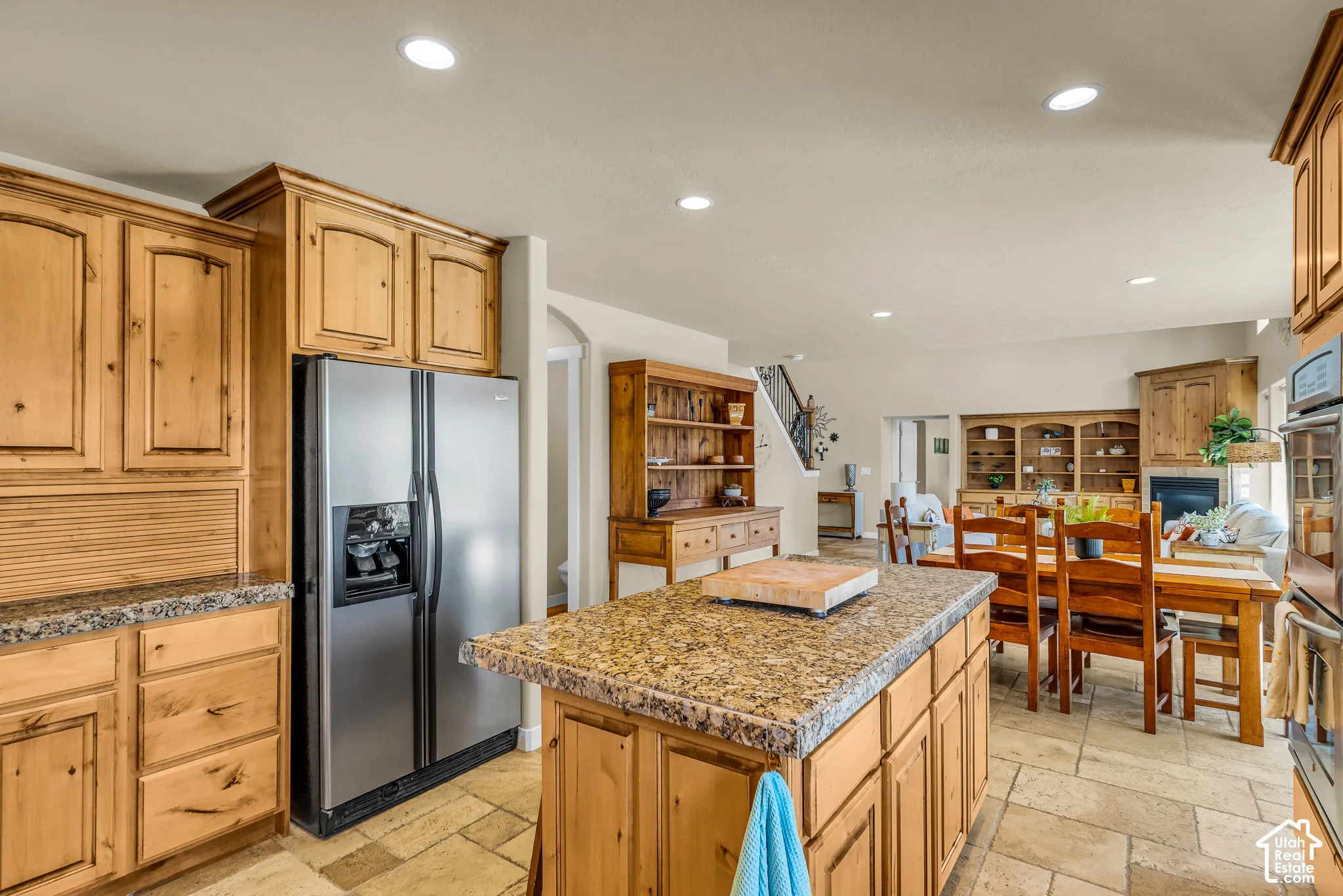 Kitchen featuring wood cabinetry, stone countertops, stainless steel appliances, recessed lighting, and tile flooring