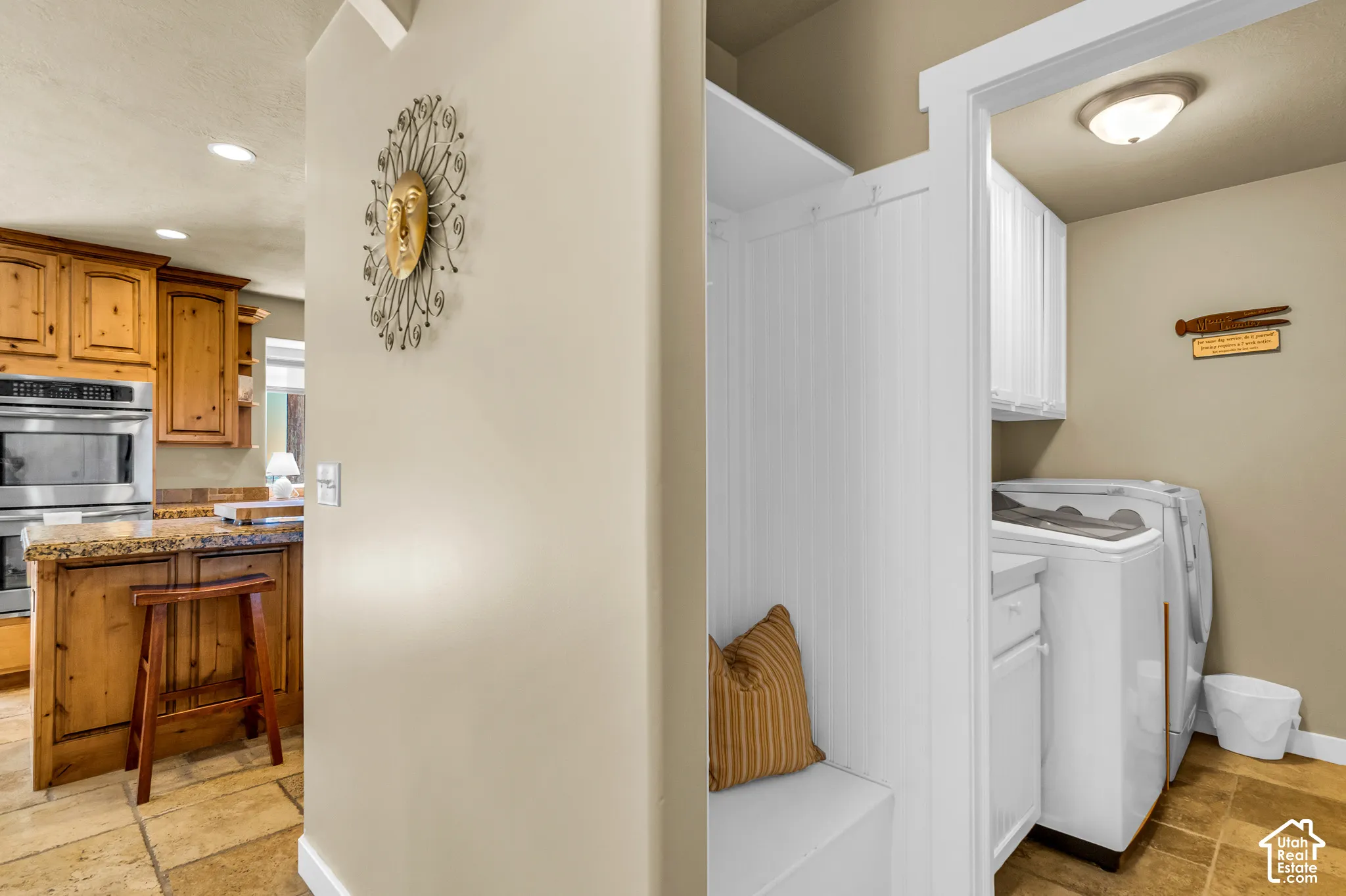 Kitchen with wood cabinetry, granite-style countertops, and stainless steel double ovens