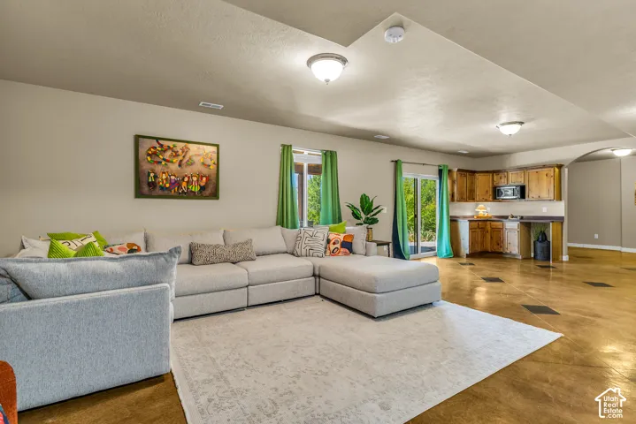 Expansive living area with large sliding glass doors, built-in cabinetry, recessed lighting, and a compact kitchen area