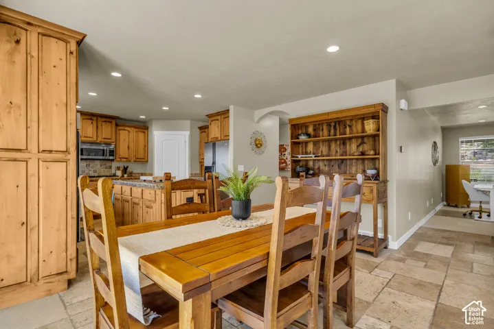 Kitchen with wood cabinetry, stainless steel appliances, and a tiled backsplash