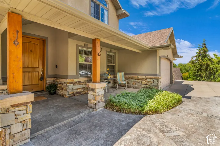 Entryway featuring stone-clad columns and a wood-paneled door