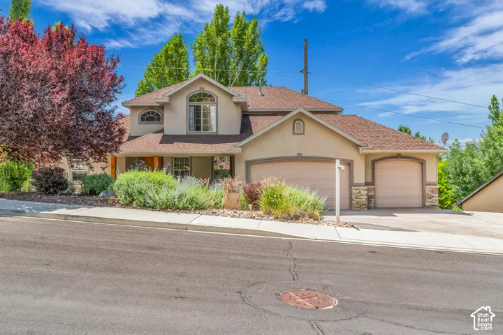 Stucco exterior with stone accents, arched windows, and a two-car garage