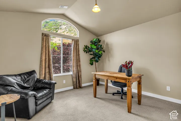 Vaulted ceiling, arched transom window, large window, neutral wall color, and carpeted flooring