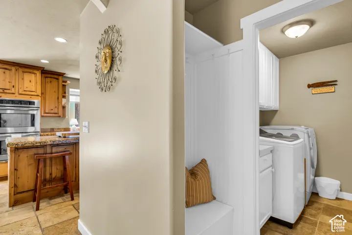 Kitchen with wood cabinetry, granite-style countertops, and stainless steel double ovens